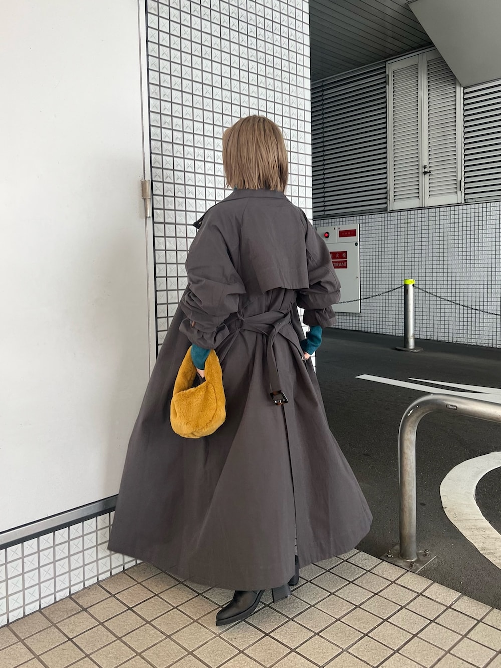 グレー系のトレンチコート、ブルー系のニット/セーター、ブラック系のその他パンツを着用したレディースの秋コーディネートの2枚目の写真