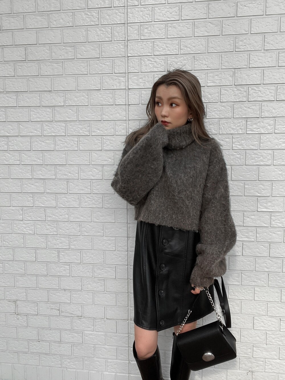 ブラック系のワンピース、ブラック系のブーツ、ブラウン系のニット/セーターを着用したレディースの秋コーディネートの3枚目の写真