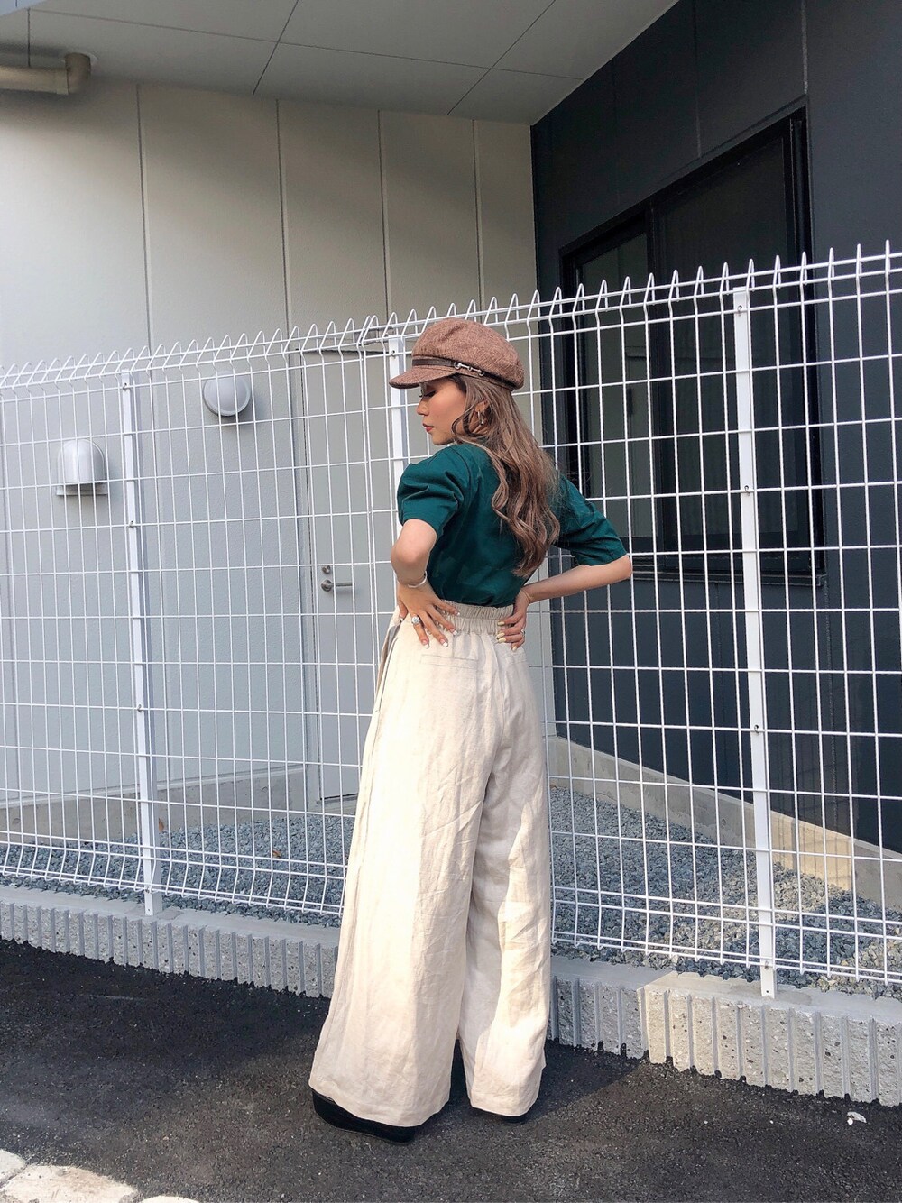 ホワイト系のその他パンツ、グリーン系のTシャツ/カットソー、ブラウン系のキャップを着用したレディースの春コーディネートの4枚目の写真