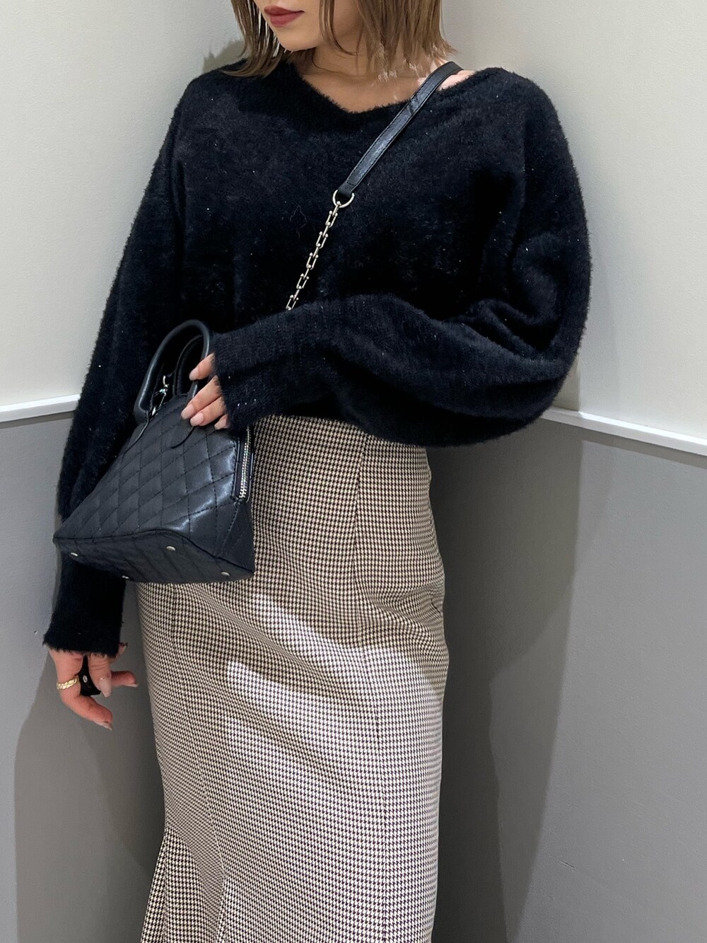 ブラック系のニット/セーター、その他のスカート、ブラック系のブーツを着用したレディースの冬コーディネートの8枚目の写真