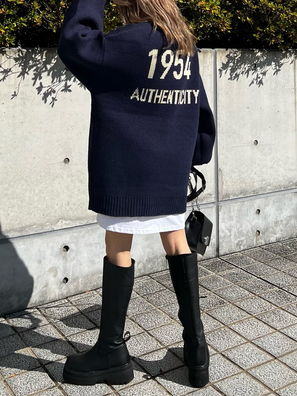 ブラック系のブーツ、ブラック系のショルダーバッグ、ホワイト系のTシャツ/カットソーを着用したレディースの秋コーディネートの8枚目の写真