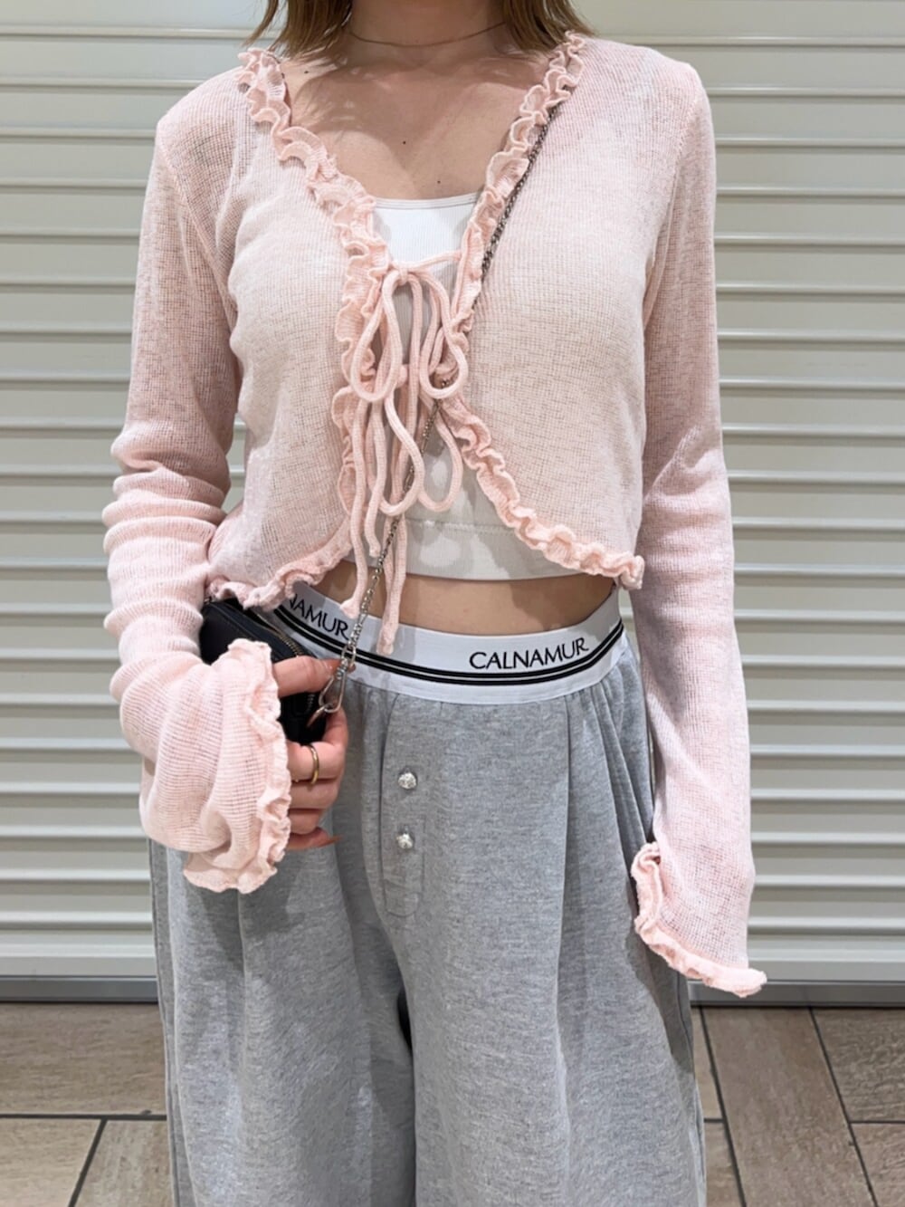 グレー系のその他パンツ、ピンク系のニット/セーターを着用したレディースの春コーディネートの6枚目の写真