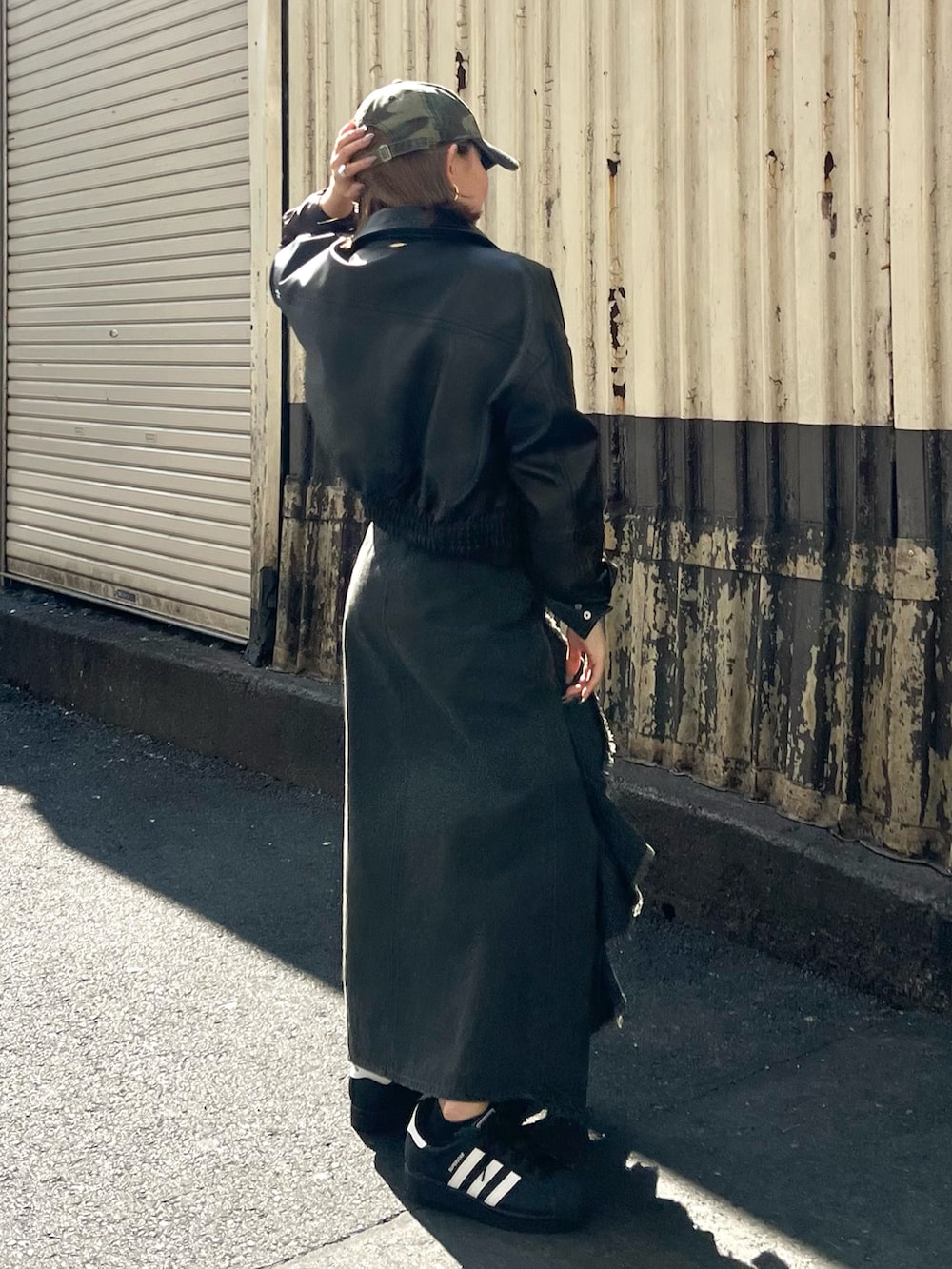 ブラウン系のブルゾン、グレー系のニット/セーター、ブラック系のスカートを着用したレディースの冬コーディネートの2枚目の写真