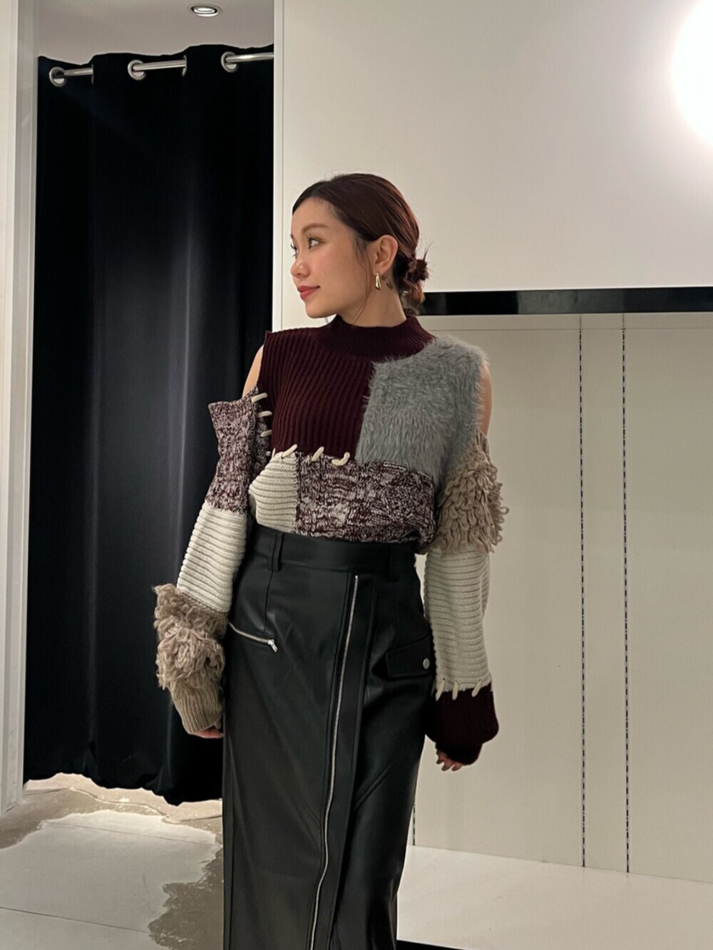 ブラック系のブーツ、レッド系のニット/セーター、ブラック系のスカートを着用したレディースの秋コーディネートの5枚目の写真