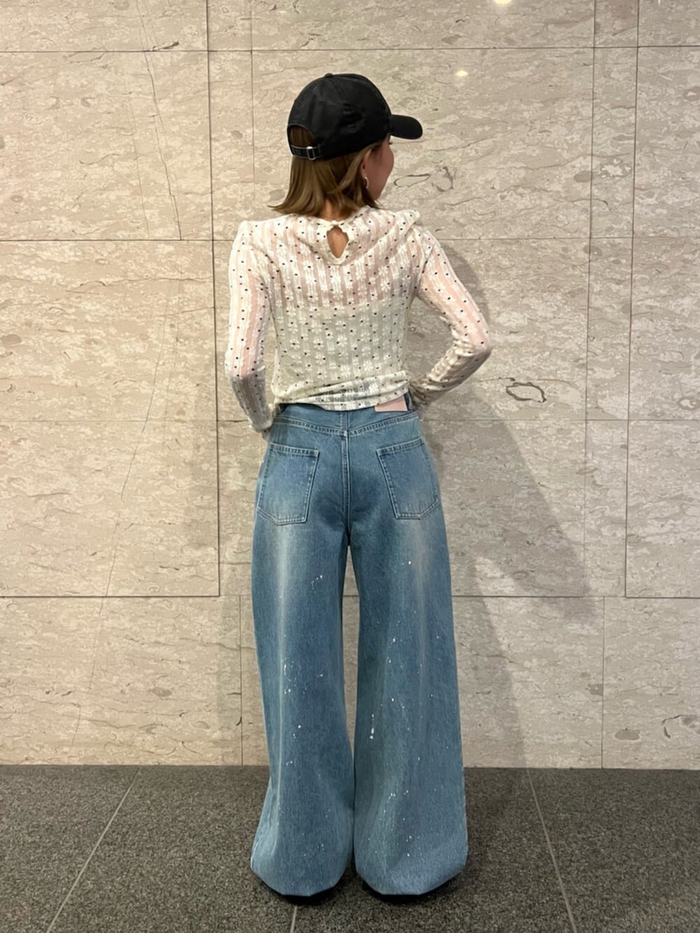 ホワイト系のTシャツ/カットソー、ブルー系のデニムパンツ、ブラック系のキャップを着用したレディースの春コーディネートの3枚目の写真