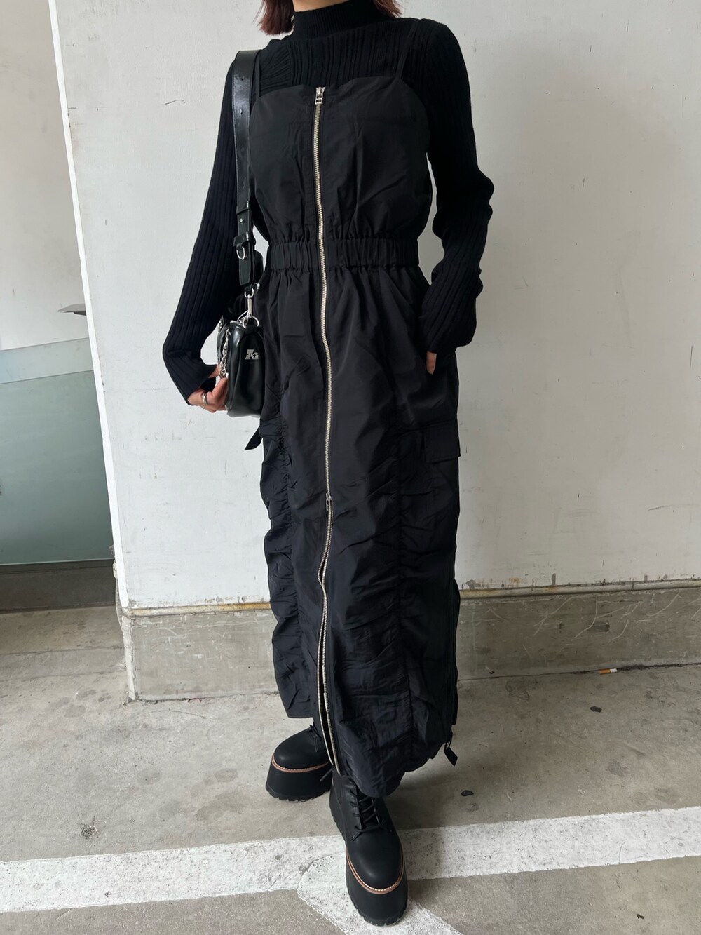 ブラック系のワンピース、ブラック系のブーツ、ブラック系のニット/セーターを着用したレディースの冬コーディネートの5枚目の写真