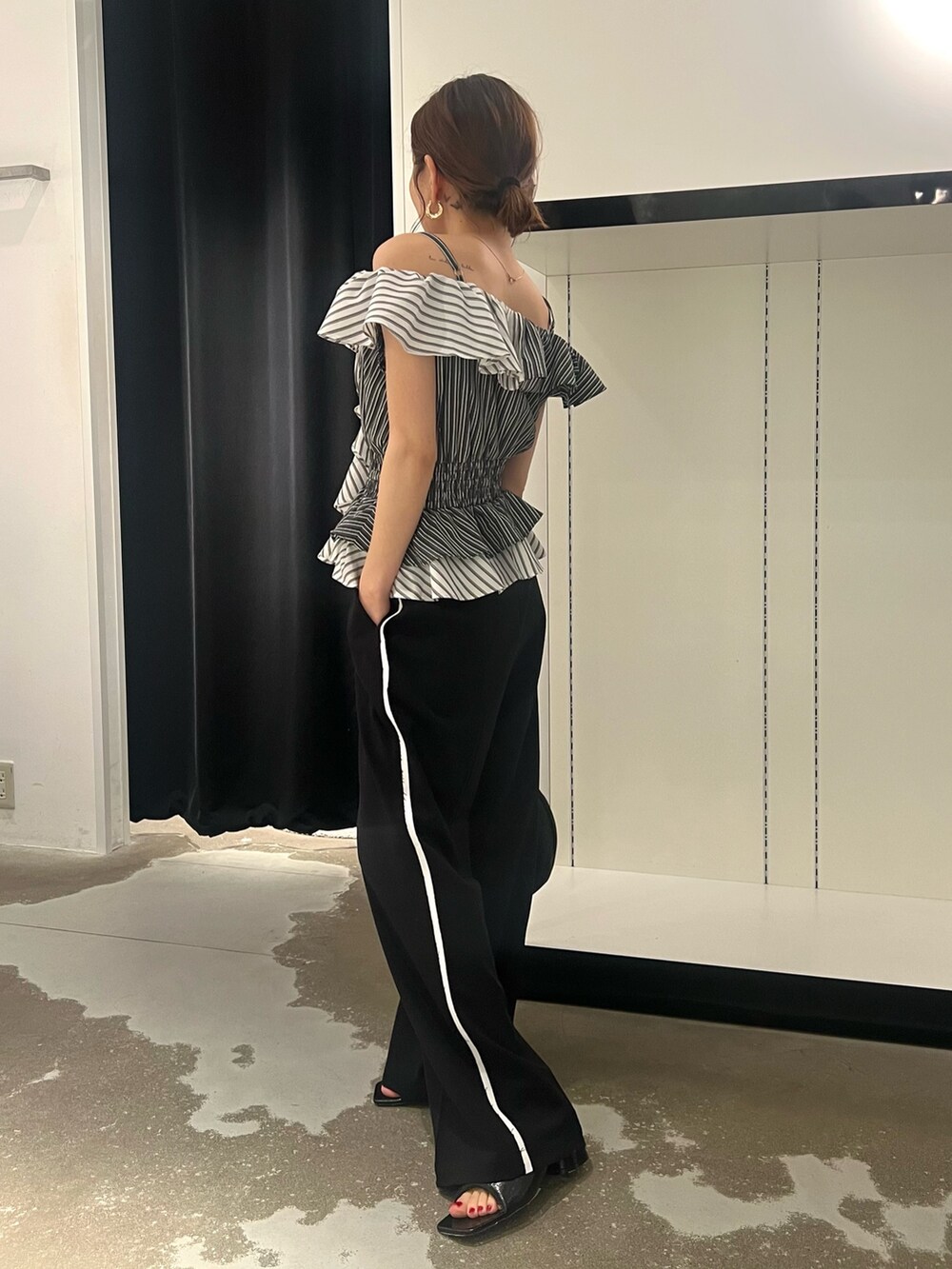 ブラック系のパンプス、ブラック系のハンドバッグ、ブラック系のその他パンツを着用したレディースの夏コーディネートの4枚目の写真