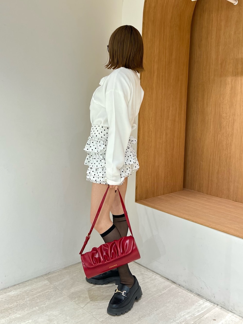 ホワイト系のニット/セーター、ホワイト系のその他パンツ、レッド系のハンドバッグを着用したレディースの冬コーディネートの2枚目の写真