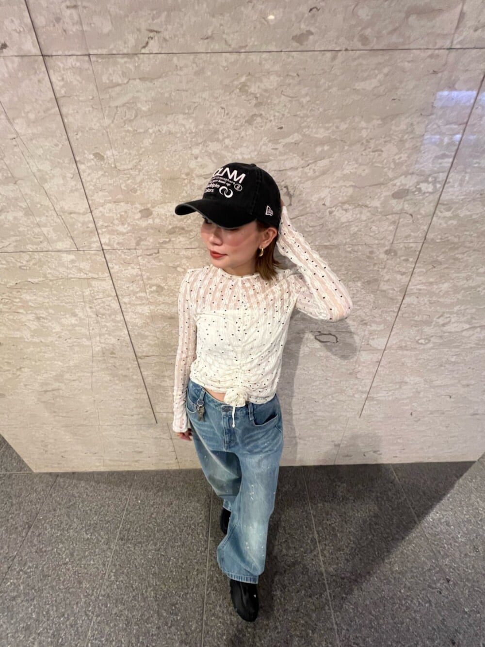 ホワイト系のTシャツ/カットソー、ブルー系のデニムパンツ、ブラック系のキャップを着用したレディースの春コーディネートの4枚目の写真