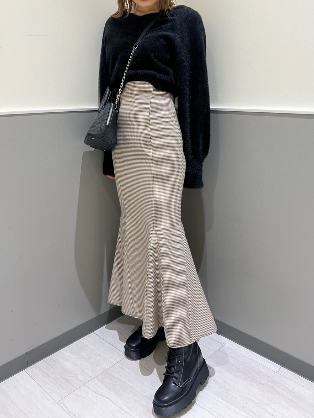 ブラック系のニット/セーター、その他のスカート、ブラック系のブーツを着用したレディースの冬コーディネートの7枚目の写真