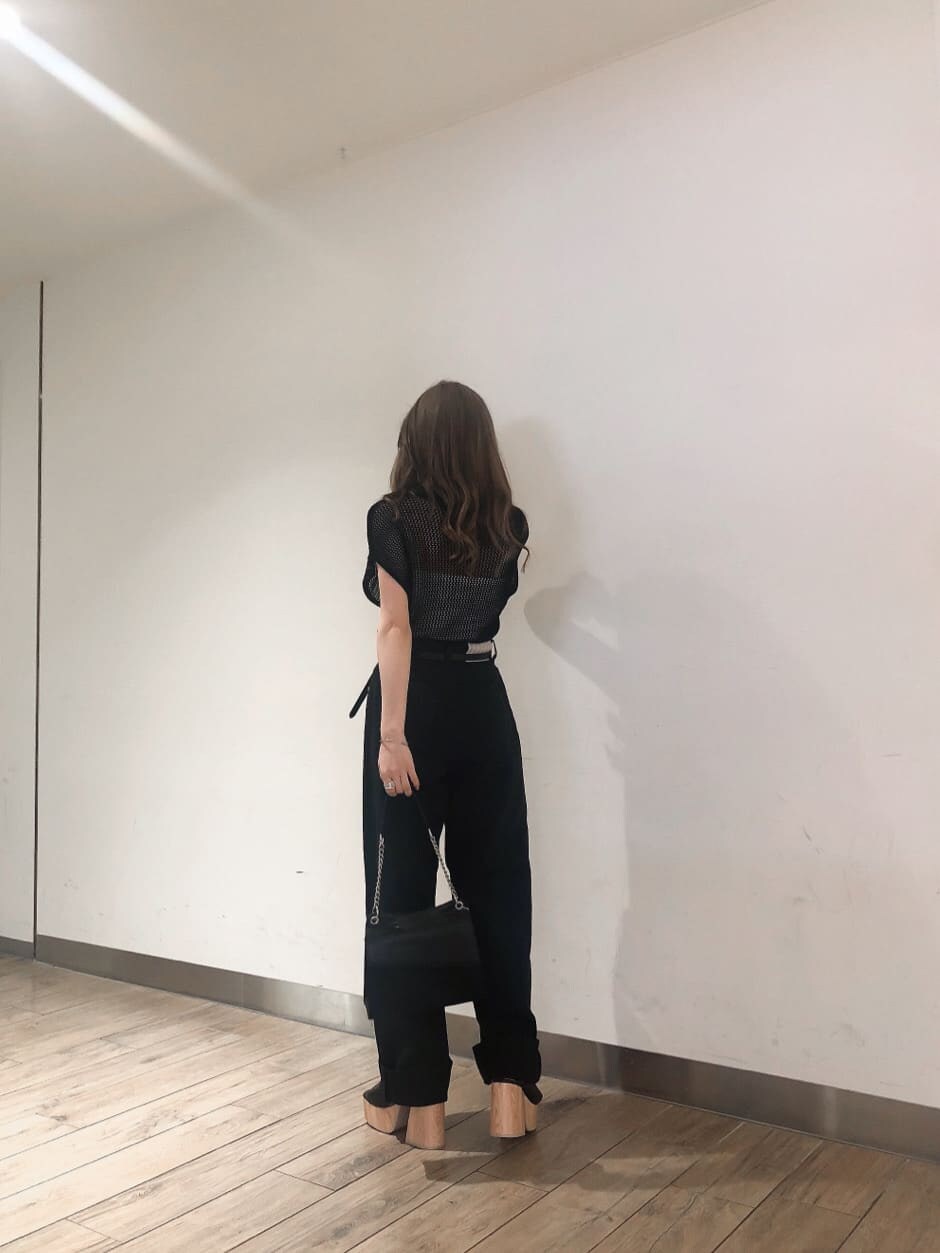 ブラック系のサンダル、ブラック系のハンドバッグ、ブラック系のデニムパンツを着用したレディースの春コーディネートの2枚目の写真