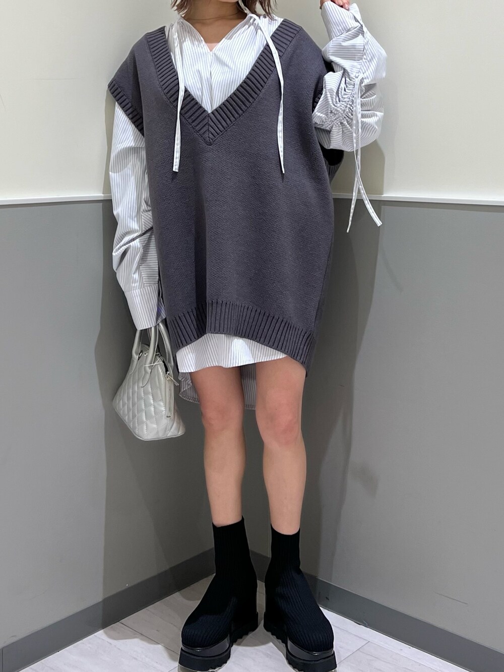 グレー系のベスト、シルバー系のハンドバッグ、その他のシャツ/ブラウスを着用したレディースの冬コーディネートの6枚目の写真