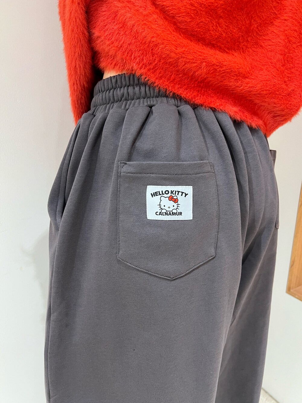 レッド系のニット/セーター、グレー系のその他パンツを着用したレディースの冬コーディネートの5枚目の写真