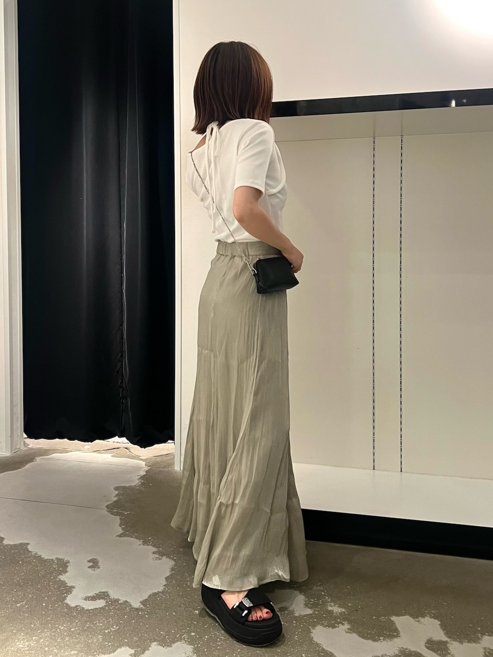 ブラック系のサンダル、ブラック系のショルダーバッグ、ホワイト系のTシャツ/カットソーを着用したレディースの夏コーディネートの2枚目の写真