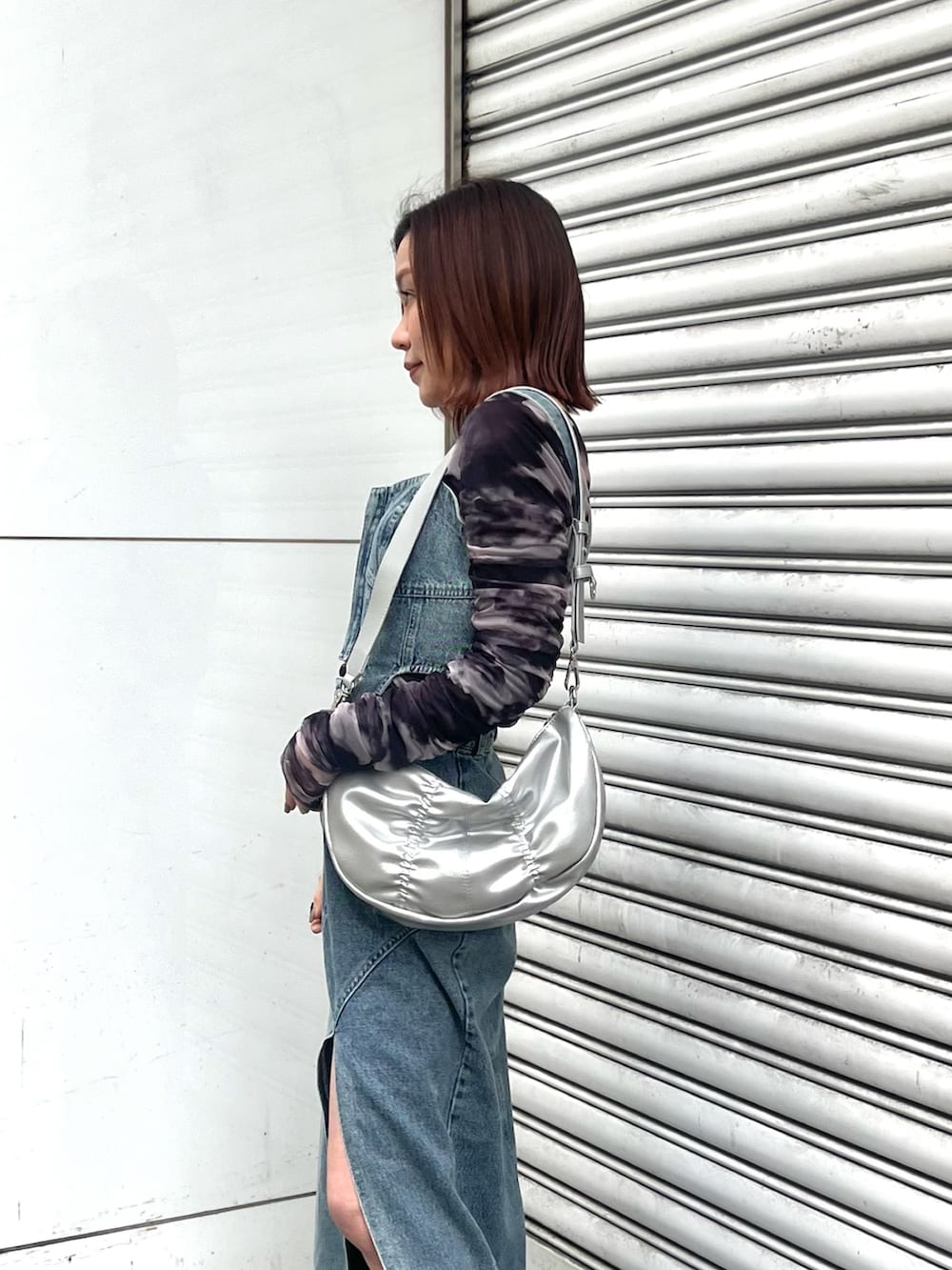 ブルー系のデニムスカート、ブルー系のその他トップス、シルバー系のショルダーバッグを着用したレディースの冬コーディネートの5枚目の写真