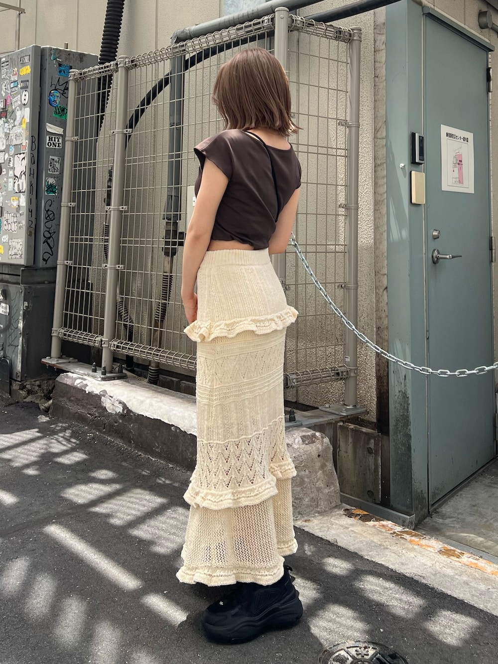 ブラウン系のTシャツ/カットソー、ホワイト系のスカートを着用したレディースの春コーディネートの2枚目の写真