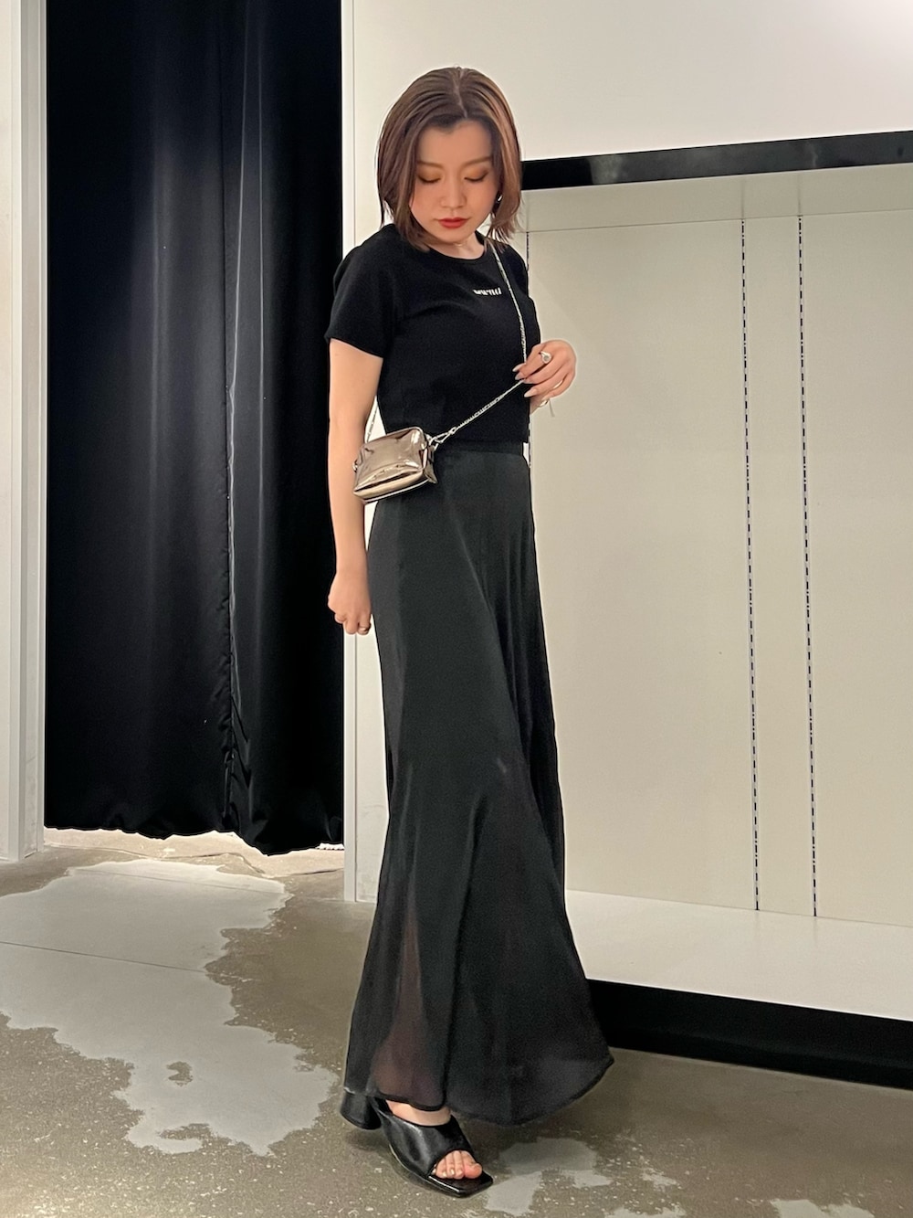 ブラック系のTシャツ/カットソー、ブラック系のスカート、ゴールド系のショルダーバッグを着用したレディースの夏コーディネートの4枚目の写真