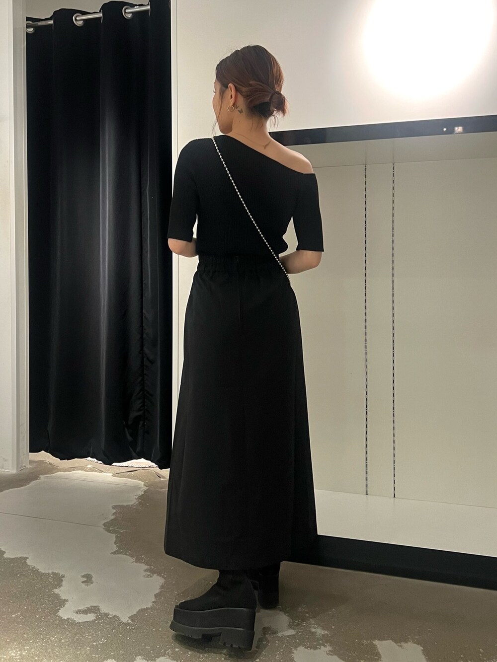 ブラック系のスカート、ブラック系のサンダル、シルバー系のショルダーバッグを着用したレディースの春コーディネートの3枚目の写真