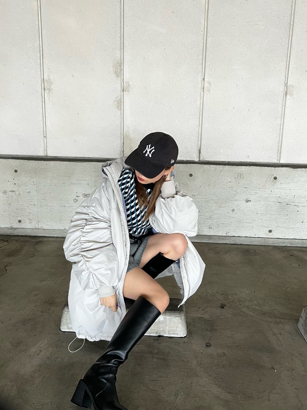 ホワイト系のブルゾン、ブラック系のニット/セーター、グレー系のスウェットパンツを着用したレディースの冬コーディネートの2枚目の写真