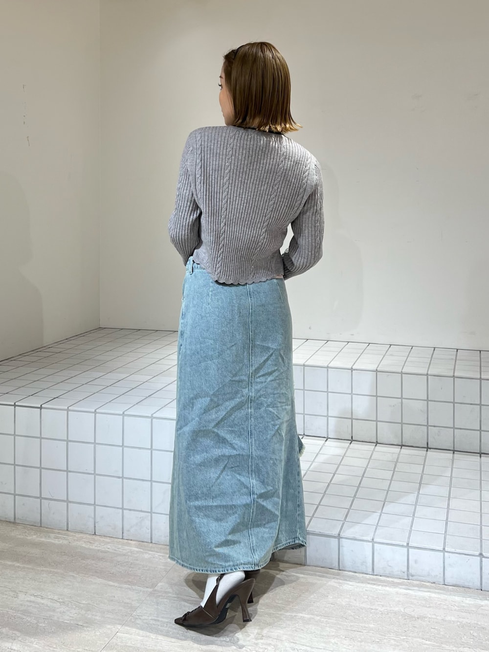 グレー系のニット/セーター、ブルー系のスカートを着用したレディースの冬コーディネートの3枚目の写真