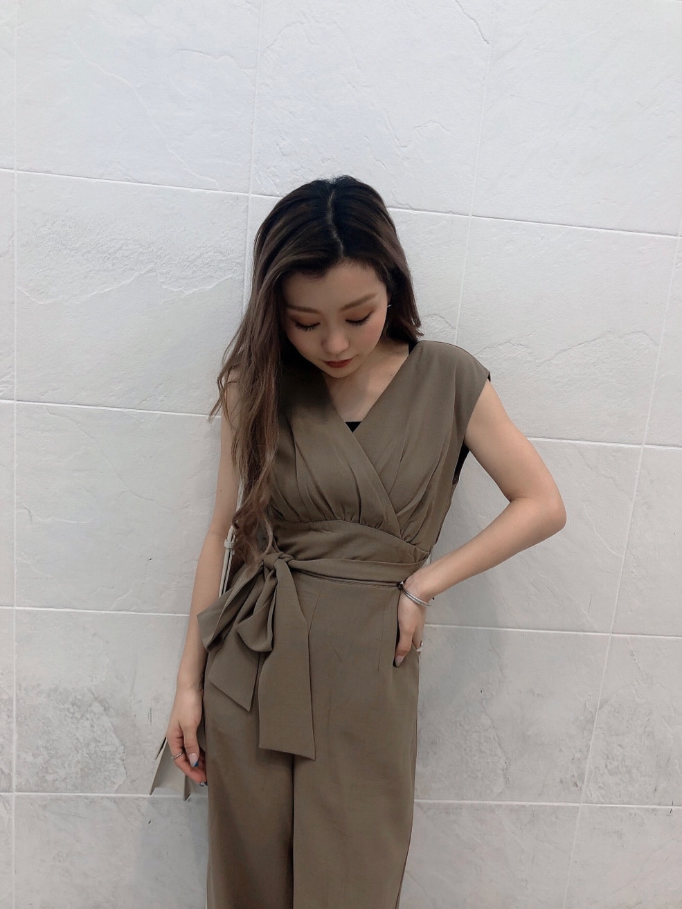 ホワイト系のサンダル、ホワイト系のハンドバッグ、ベージュ系のつなぎ/オールインワンを着用したレディースの夏コーディネートの3枚目の写真