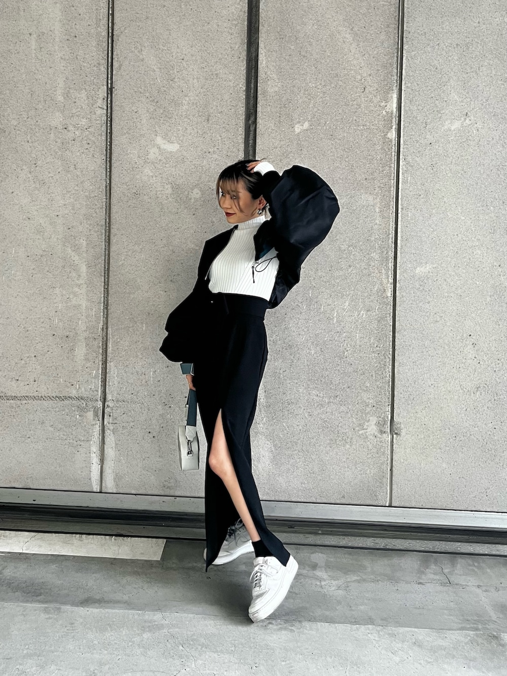 ブラック系のMA-1、ホワイト系のニット/セーター、ブラック系のスカートを着用したレディースの冬コーディネートの4枚目の写真