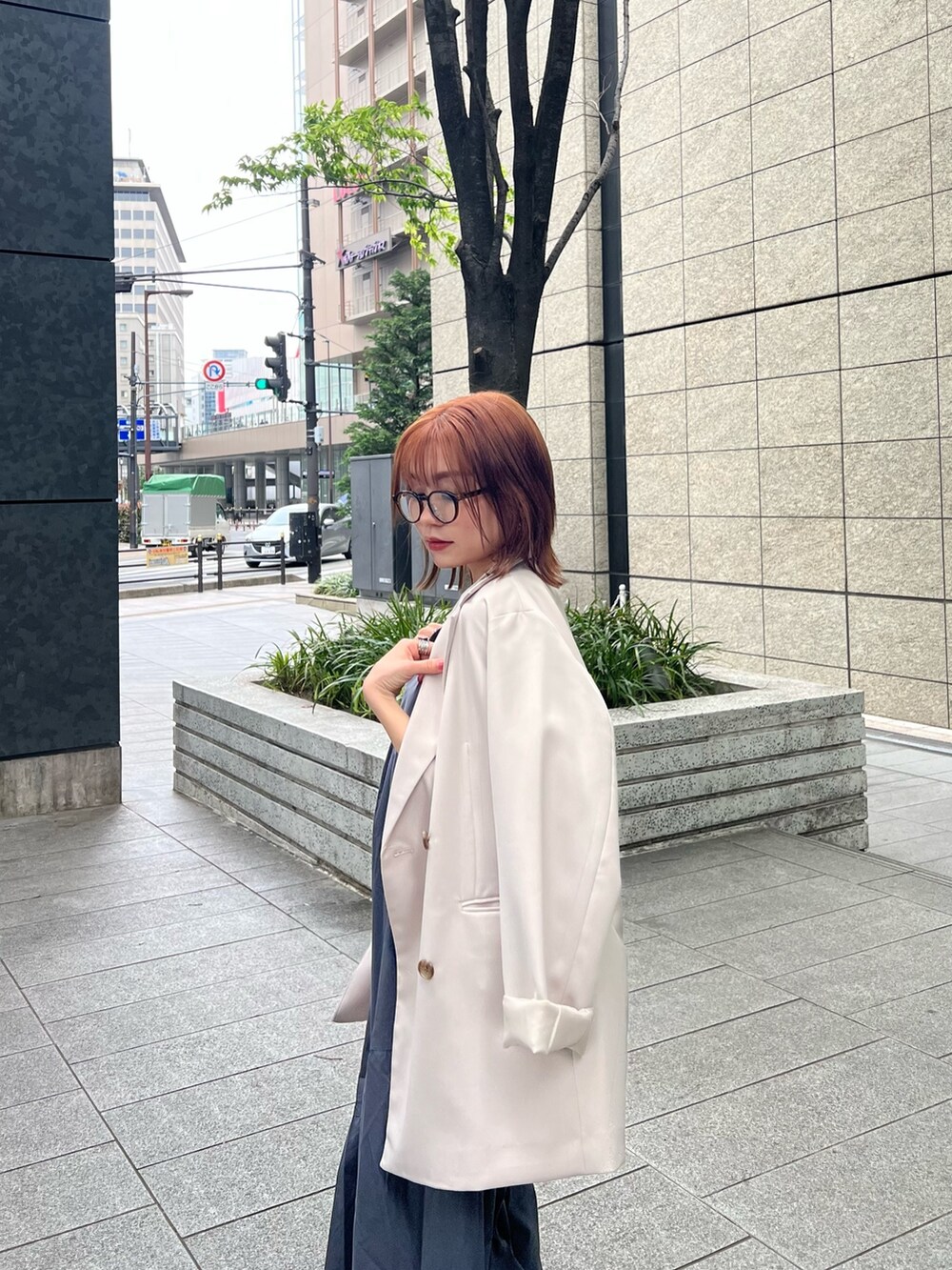 ベージュ系のテーラードジャケット、ブラウン系のニット/セーター、グレー系のワンピースを着用したレディースの春コーディネートの7枚目の写真