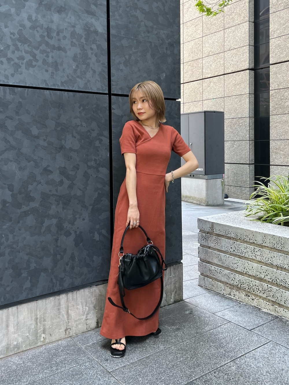 オレンジ系のワンピース、ブラック系のサンダルを着用したレディースの夏コーディネートの3枚目の写真