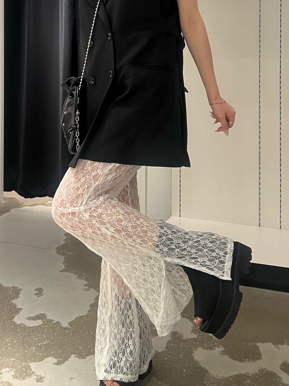 ブラック系のベスト、ホワイト系のその他パンツ、ブラック系のサンダルを着用したレディースの春コーディネートの6枚目の写真