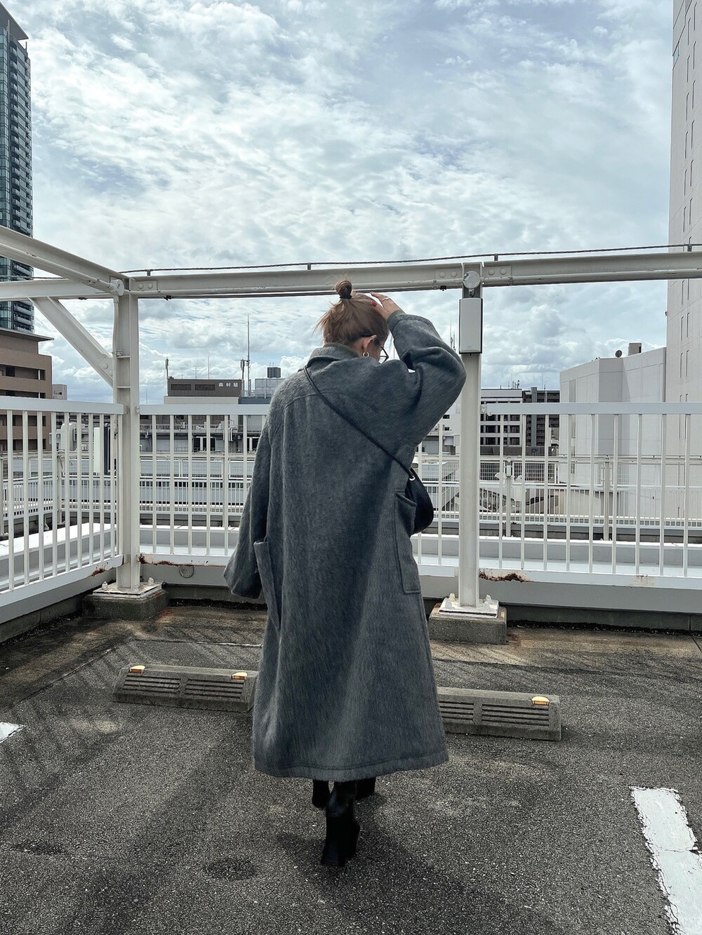 ブラック系のワンピース、グリーン系のニット/セーター、ブラック系のブーツを着用したレディースの秋コーディネートの5枚目の写真