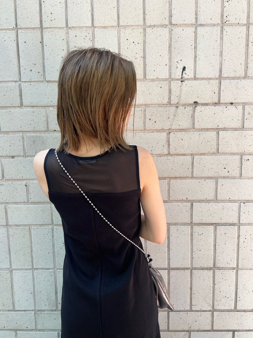 ブラック系のワンピース、シルバー系のサンダル、ブラック系のショルダーバッグを着用したレディースの夏コーディネートの7枚目の写真