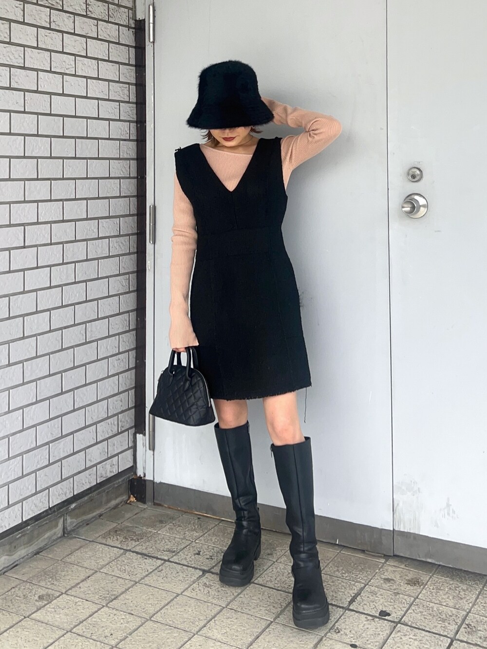 ベージュ系のニット/セーター、ブラック系のワンピース、ブラック系のブーツを着用したレディースの冬コーディネートの3枚目の写真