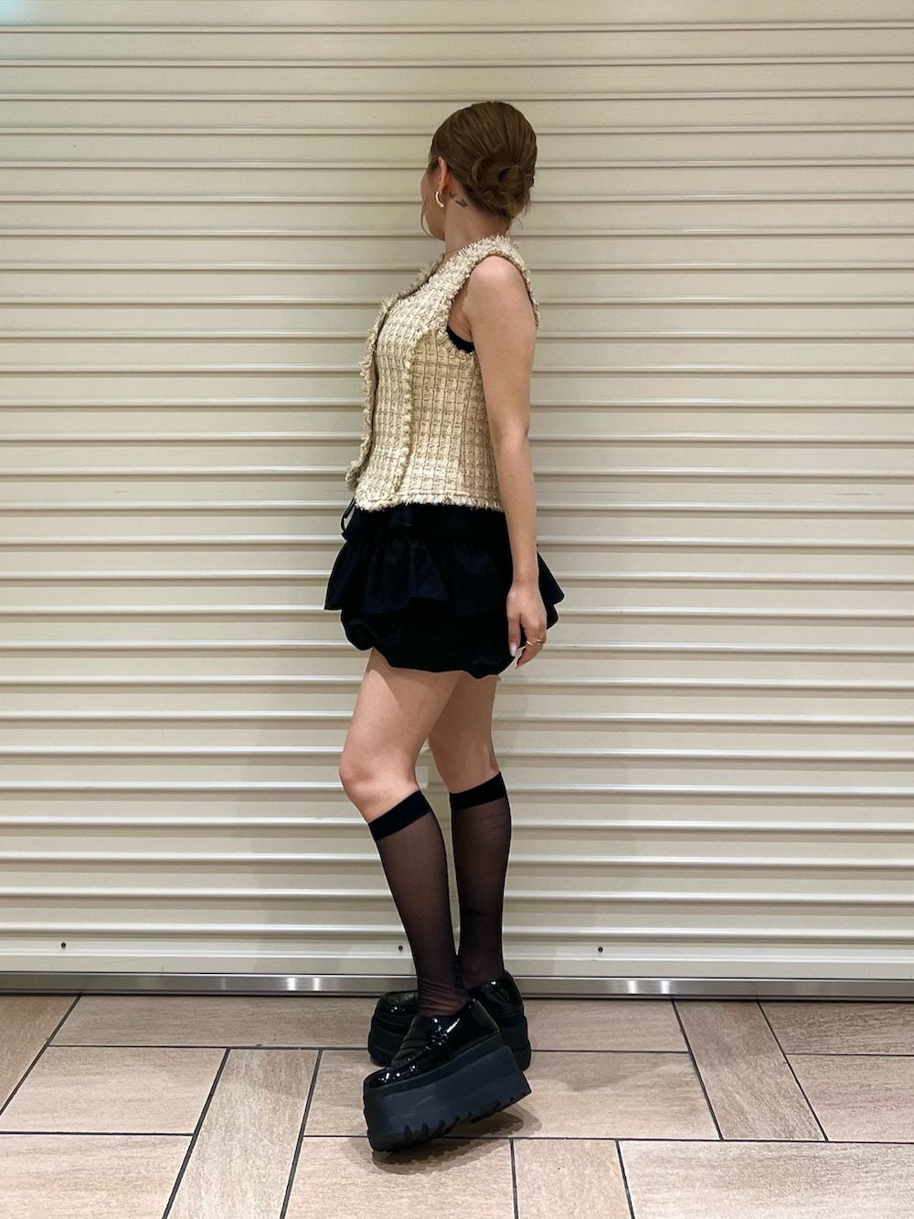 ベージュ系のベスト、ブラック系のその他パンツを着用したレディースの夏コーディネートの2枚目の写真