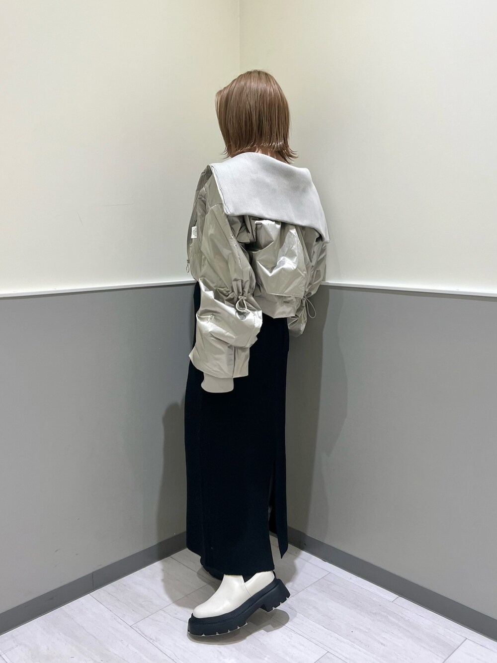 ブラック系のニット/セーター、シルバー系のブルゾン、ブラック系のスカートを着用したレディースの冬コーディネートの4枚目の写真