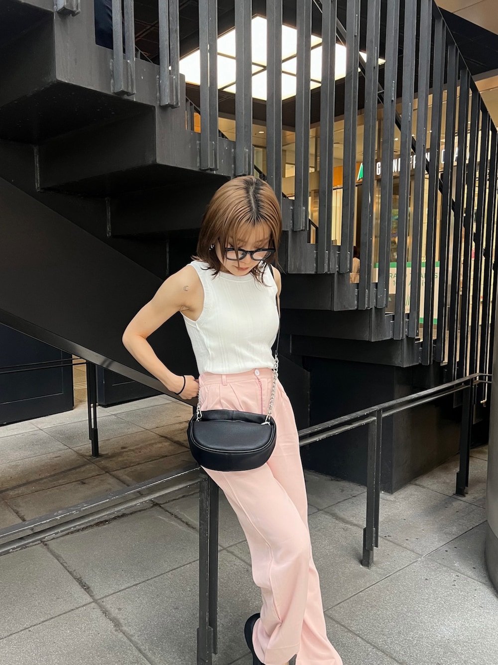 ブラック系のサンダル、ブラック系のハンドバッグ、ホワイト系のTシャツ/カットソーを着用したレディースの夏コーディネートの4枚目の写真