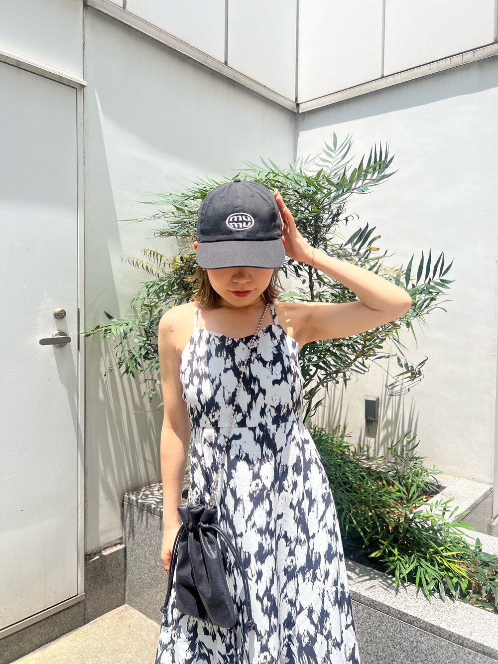 ホワイト系のワンピース、ブラック系のショルダーバッグ、ブラック系のサンダルを着用したレディースの夏コーディネートの7枚目の写真