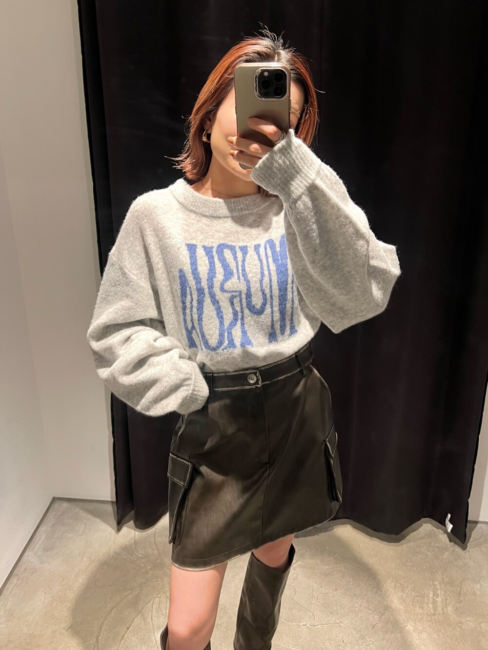 グレー系のニット/セーター、ブラウン系のブーツ、ブラウン系のスカートを着用したレディースの冬コーディネートの4枚目の写真