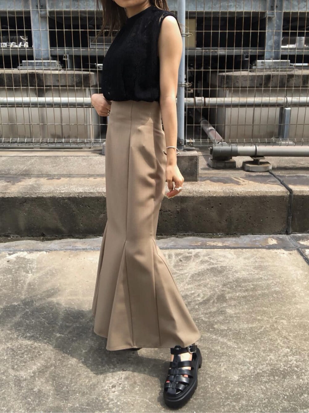 ベージュ系のスカート、ブラック系のサンダル、ブラック系のシャツ/ブラウスを着用したレディースの夏コーディネートの4枚目の写真