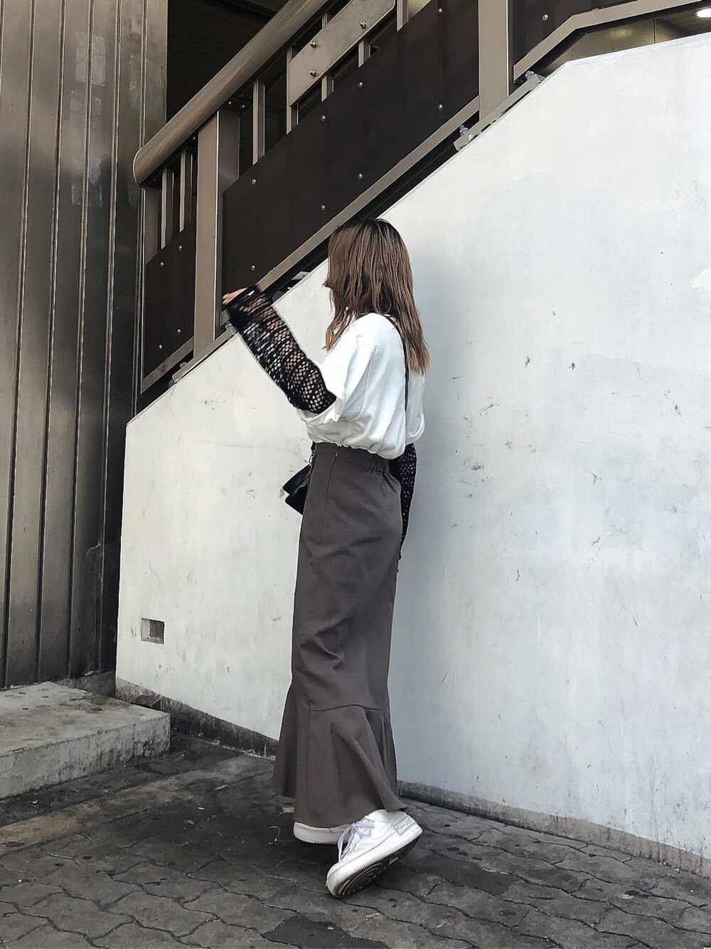 グレー系のスカート、ブラック系のハンドバッグ、ホワイト系のTシャツ/カットソーを着用したレディースの春コーディネートの6枚目の写真