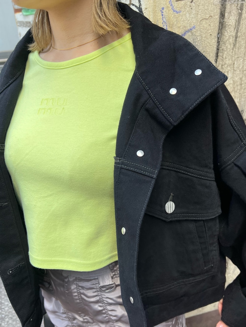 イエロー系のTシャツ/カットソー、ブラック系のデニムジャケット、グレー系のスカートを着用したレディースの春コーディネートの7枚目の写真