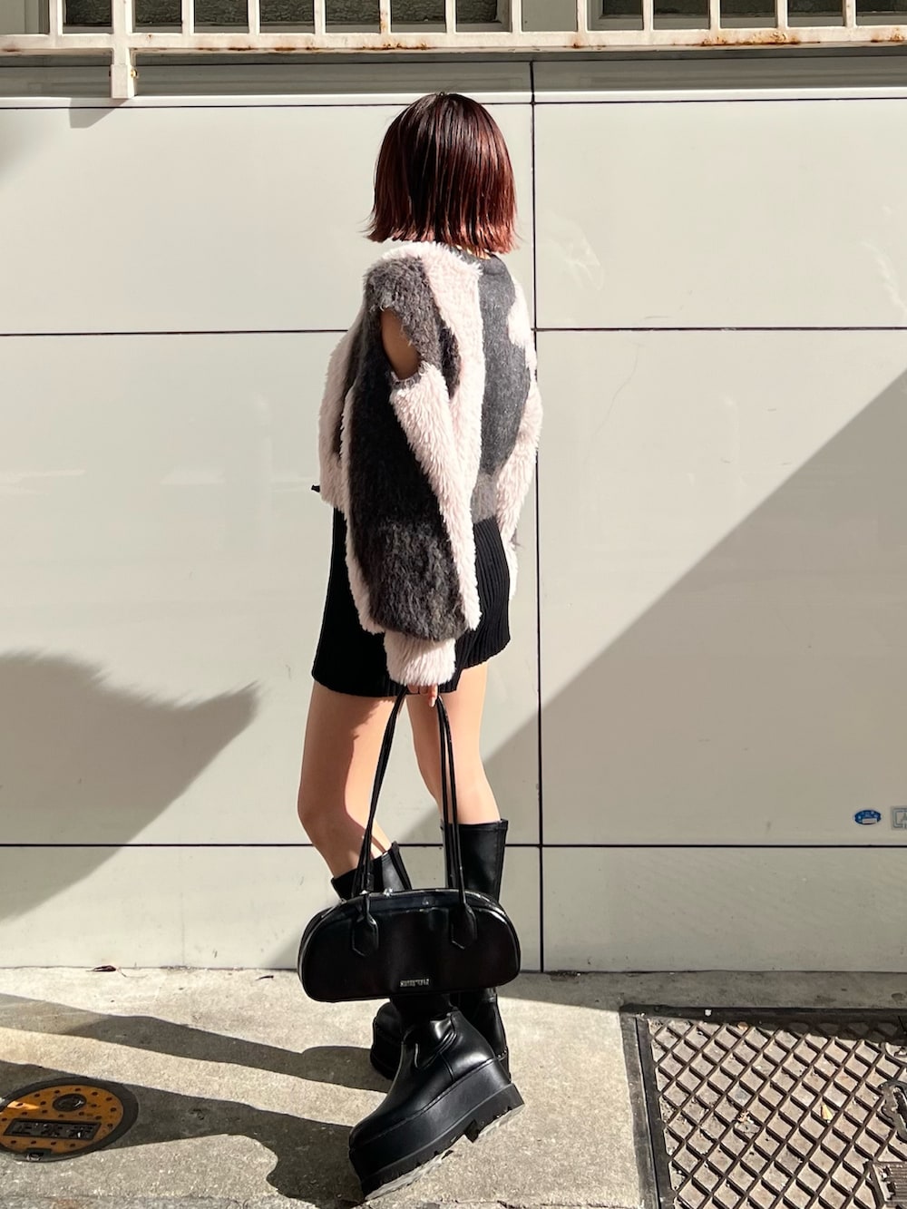 ブラック系のその他パンツ、ブラック系のボストンバッグ、ブラック系のブーツを着用したレディースの冬コーディネートの2枚目の写真