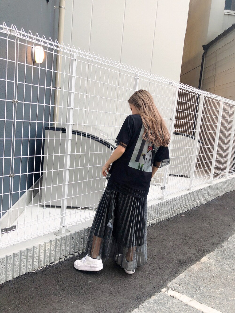 ブラック系のショルダーバッグ、ブラック系のスカート、ブラック系のTシャツ/カットソーを着用したレディースの春コーディネートの3枚目の写真