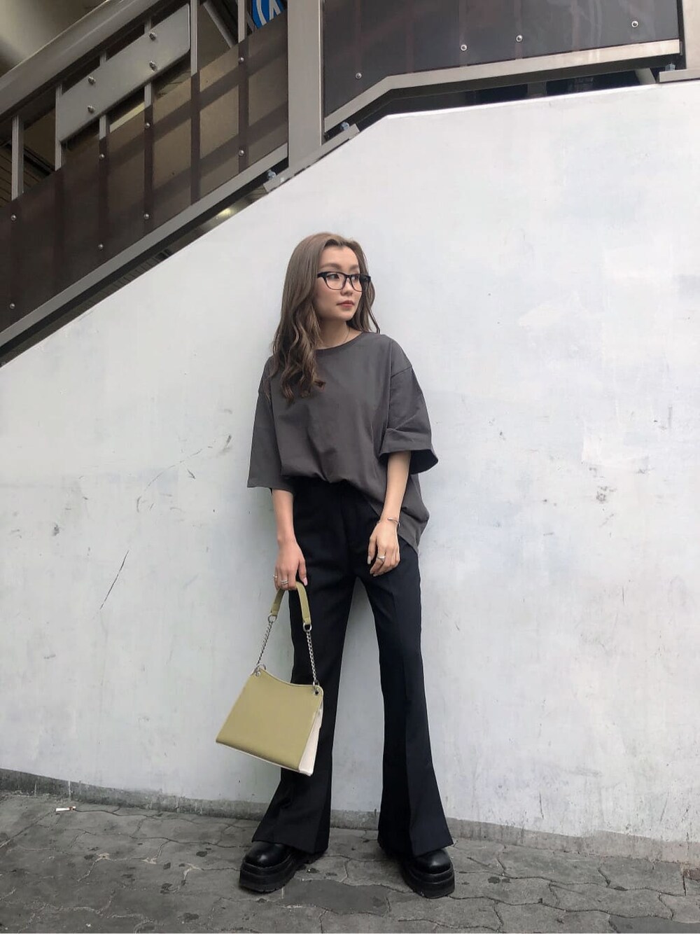 ブラック系のスラックス、ホワイト系のハンドバッグ、グレー系のTシャツ/カットソーを着用したレディースの春コーディネートの5枚目の写真