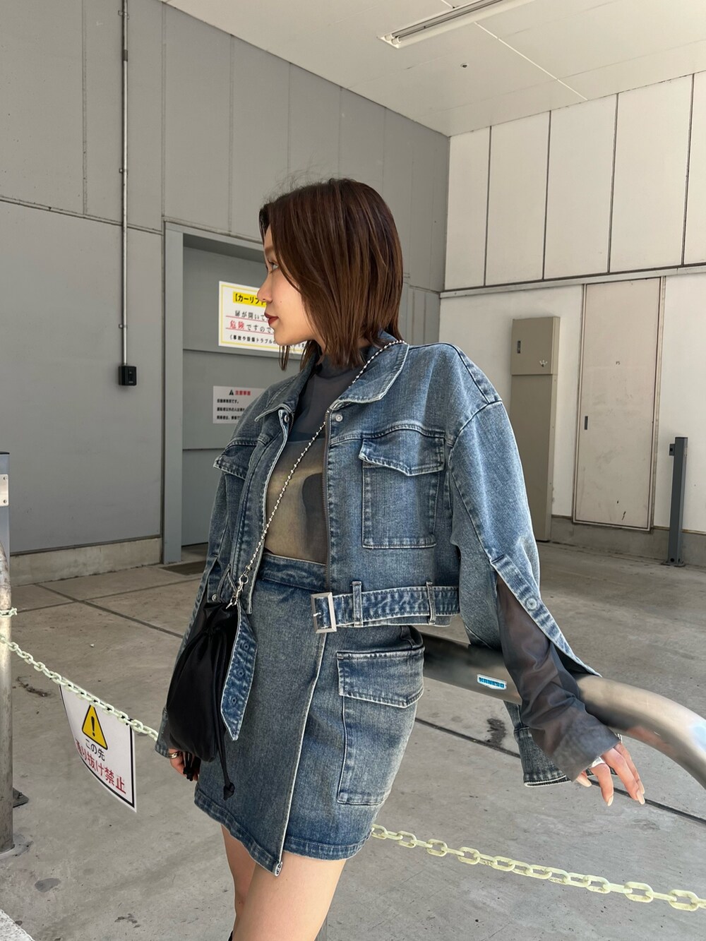 ブラック系のショルダーバッグ、ブラック系のブーツ、その他のTシャツ/カットソーを着用したレディースの夏コーディネートの5枚目の写真