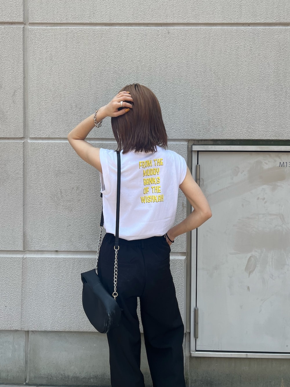 ホワイト系のタンクトップ、ブラック系のハンドバッグ、ブラック系のサンダルを着用したレディースの春コーディネートの5枚目の写真