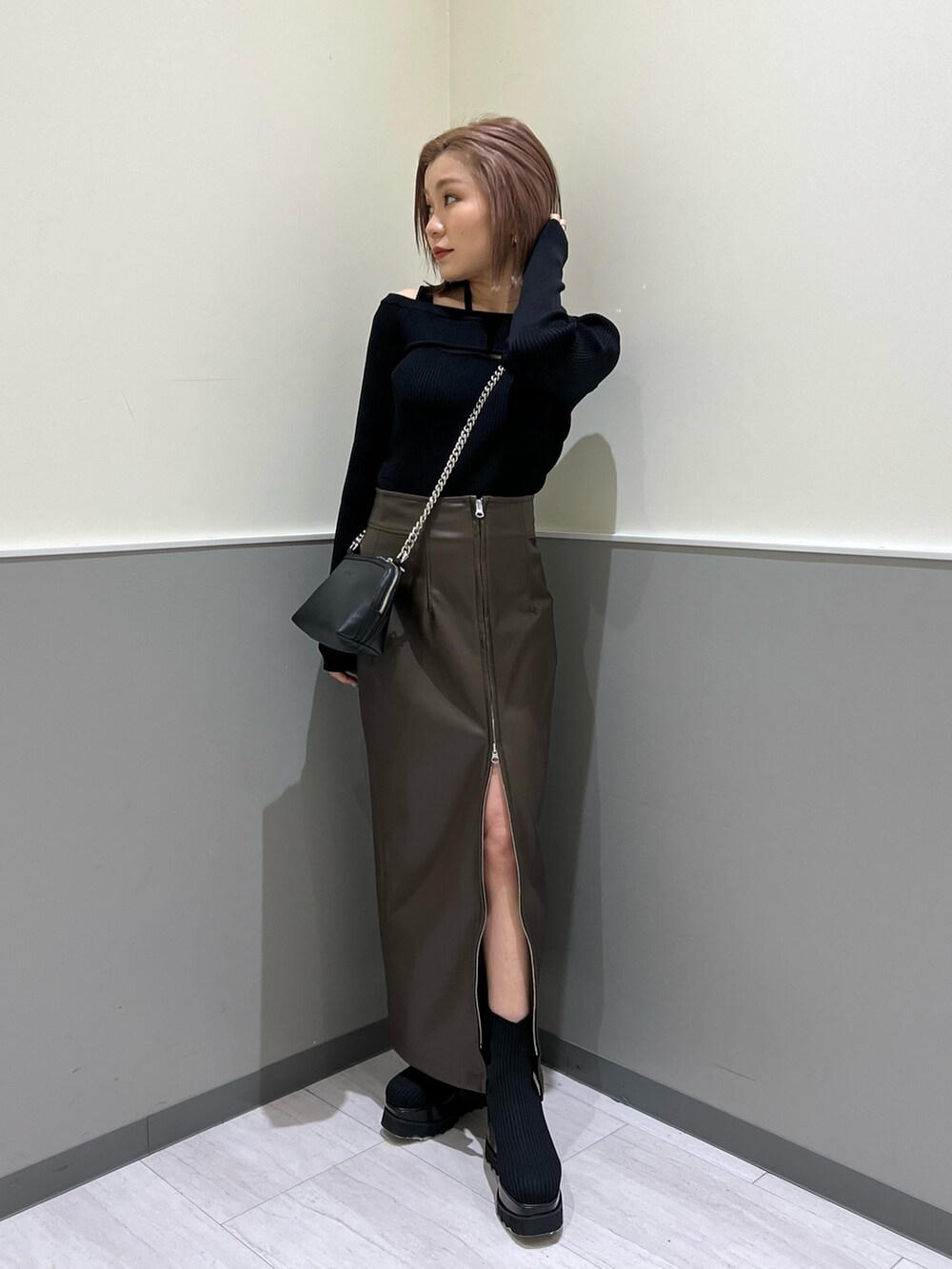 ブラック系のニット/セーター、ブラック系のブーツ、ブラウン系のスカートを着用したレディースの冬コーディネートの2枚目の写真