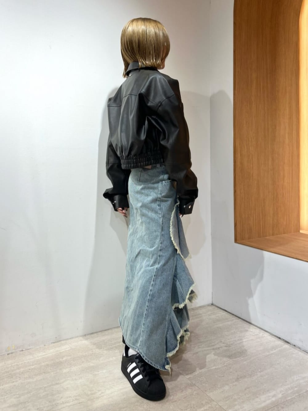 ブルー系のスカート、ブルー系のニット/セーター、ブラウン系のブルゾンを着用したレディースの冬コーディネートの2枚目の写真