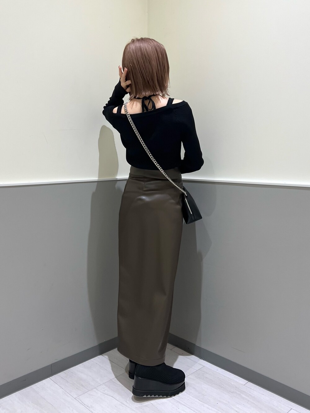 ブラック系のニット/セーター、ブラック系のブーツ、ブラウン系のスカートを着用したレディースの冬コーディネートの4枚目の写真