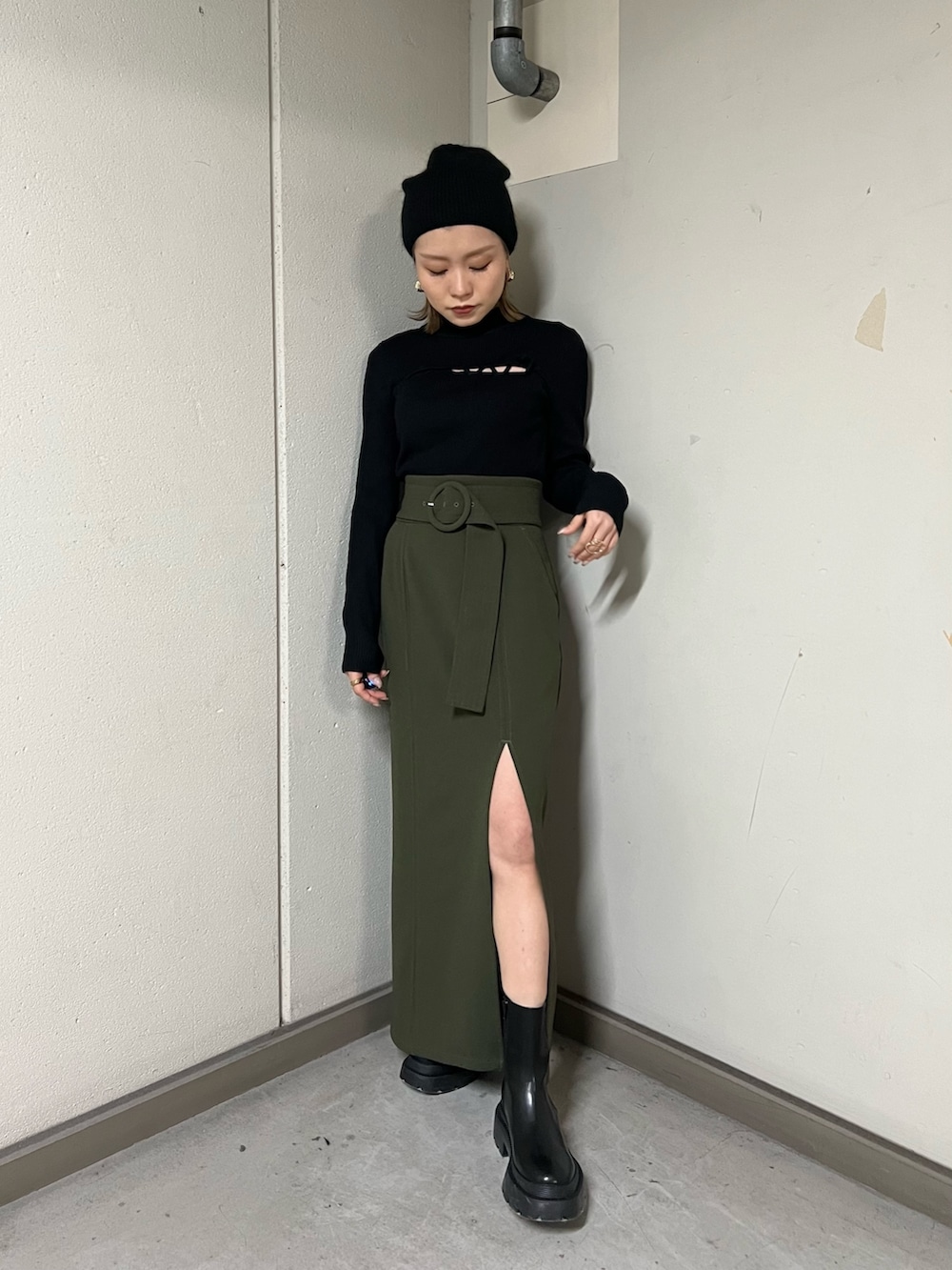 ブラック系のムートンコート、ブラック系のニット/セーター、グリーン系のスカートを着用したレディースの冬コーディネートの7枚目の写真