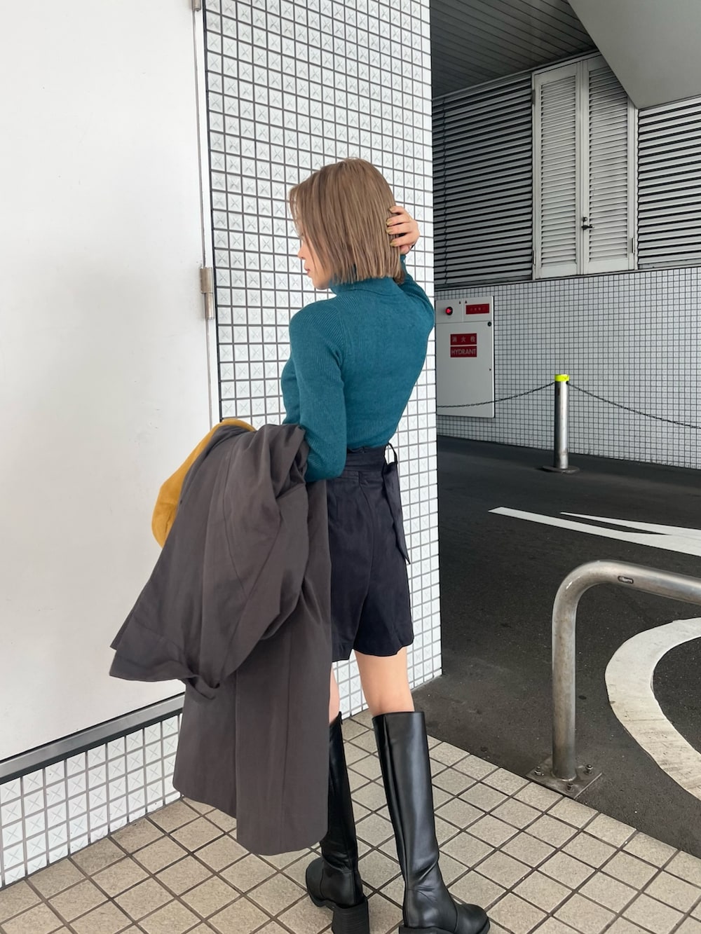 グレー系のトレンチコート、ブルー系のニット/セーター、ブラック系のその他パンツを着用したレディースの秋コーディネートの6枚目の写真